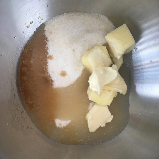wet ingredients measured into a stainless still bowl including room temperature butter, sugar, grape seed oil and vanilla just before being mixed