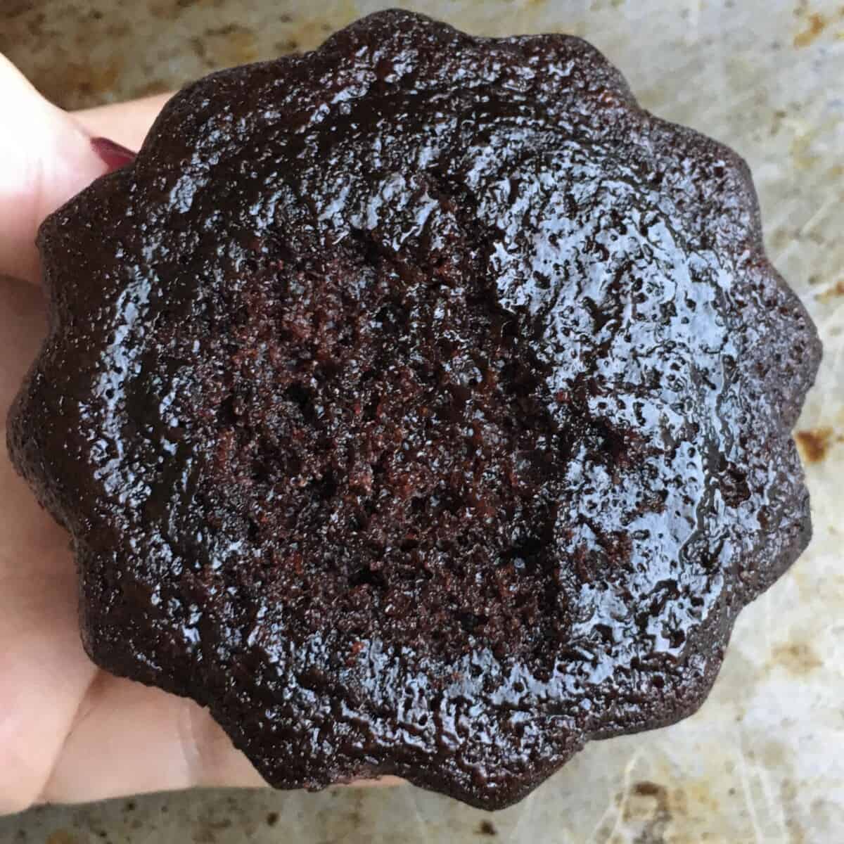 a mini devil's food cake bundt cake showing the bottom and how moist it is with a slight sheen and part of the inner crumb revealed when I pulled it off of the parchment paper and the bottom stuck. It's SO moist it's incredible.