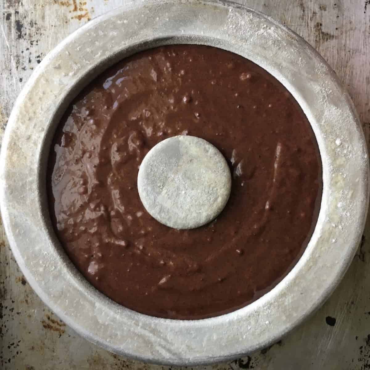 Devil's food cake batter in ding dong shaped ring in a specialty fillable cake pan, a creative devil's food cake recipe idea for making chocolate devil cakes with cream filling.