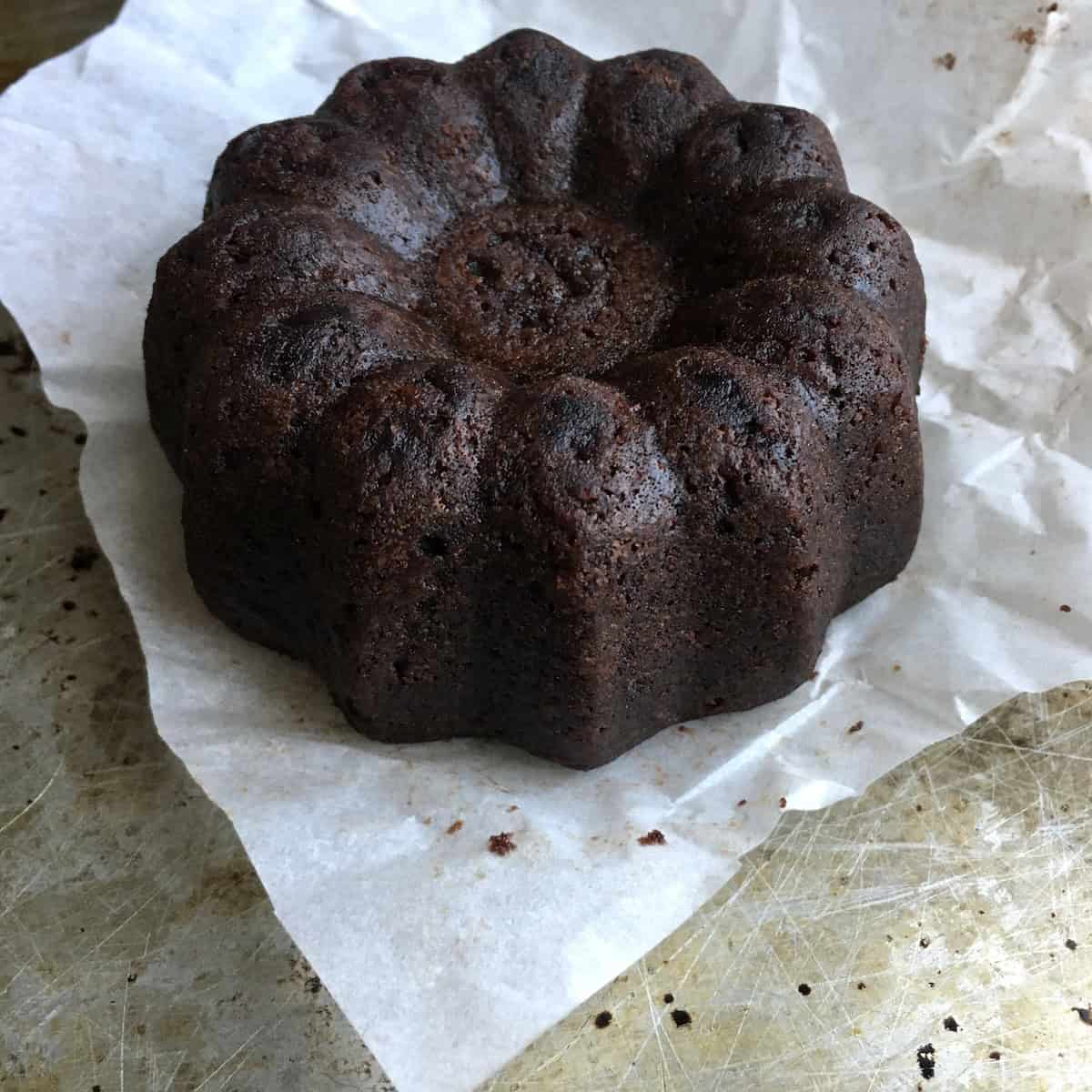 Single baked mini devil's food cake bundt showing the dark mahogany color and moist texture of this devil chocolate cake recipe from scratch perfect for individual desserts.
