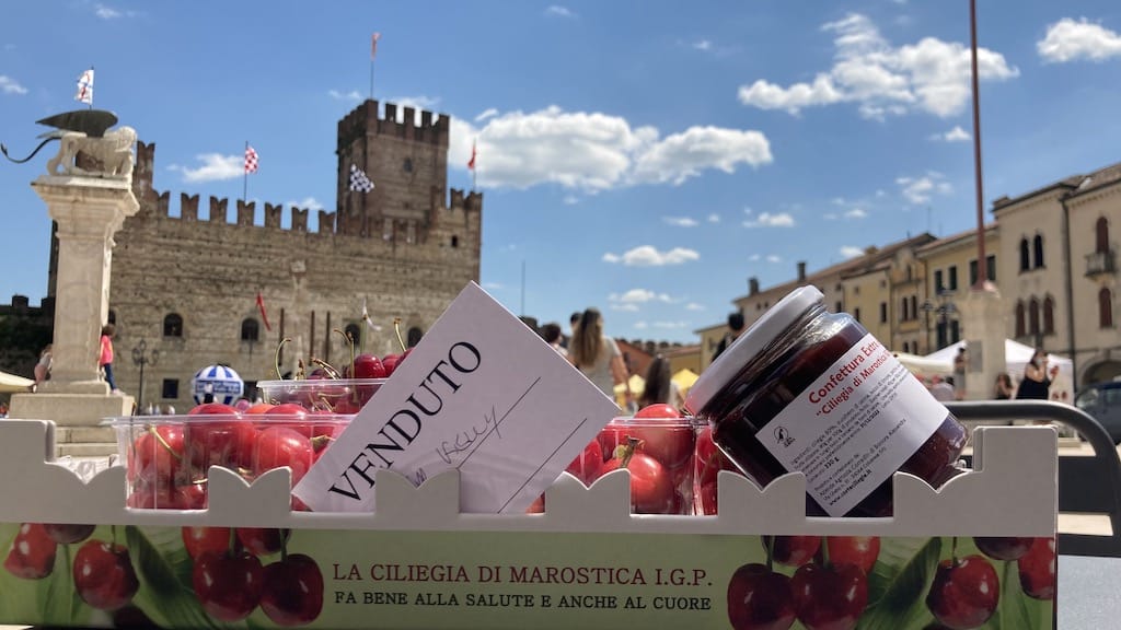 a view of my reserved cherries and the castle of Marostica, Italy and the blue skies with perfect white clouds in the background