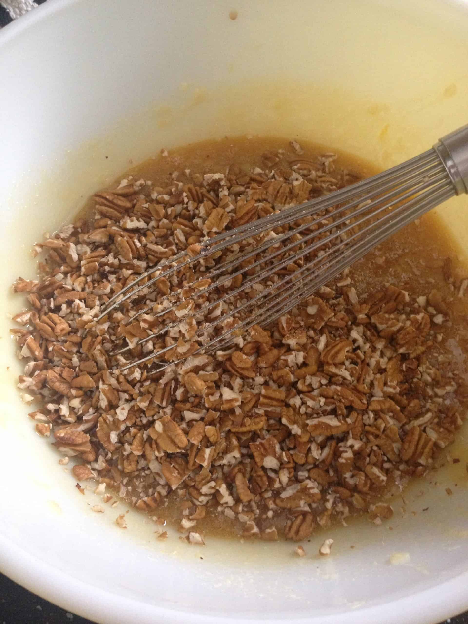southern pecan pie mixture in bowl with whisk