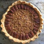 perfectly baked golden brown pecan pie on a metal sheet tray
