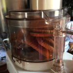rectangular Biscoff Lotus cookies in the bowl of the food processor with the lid on