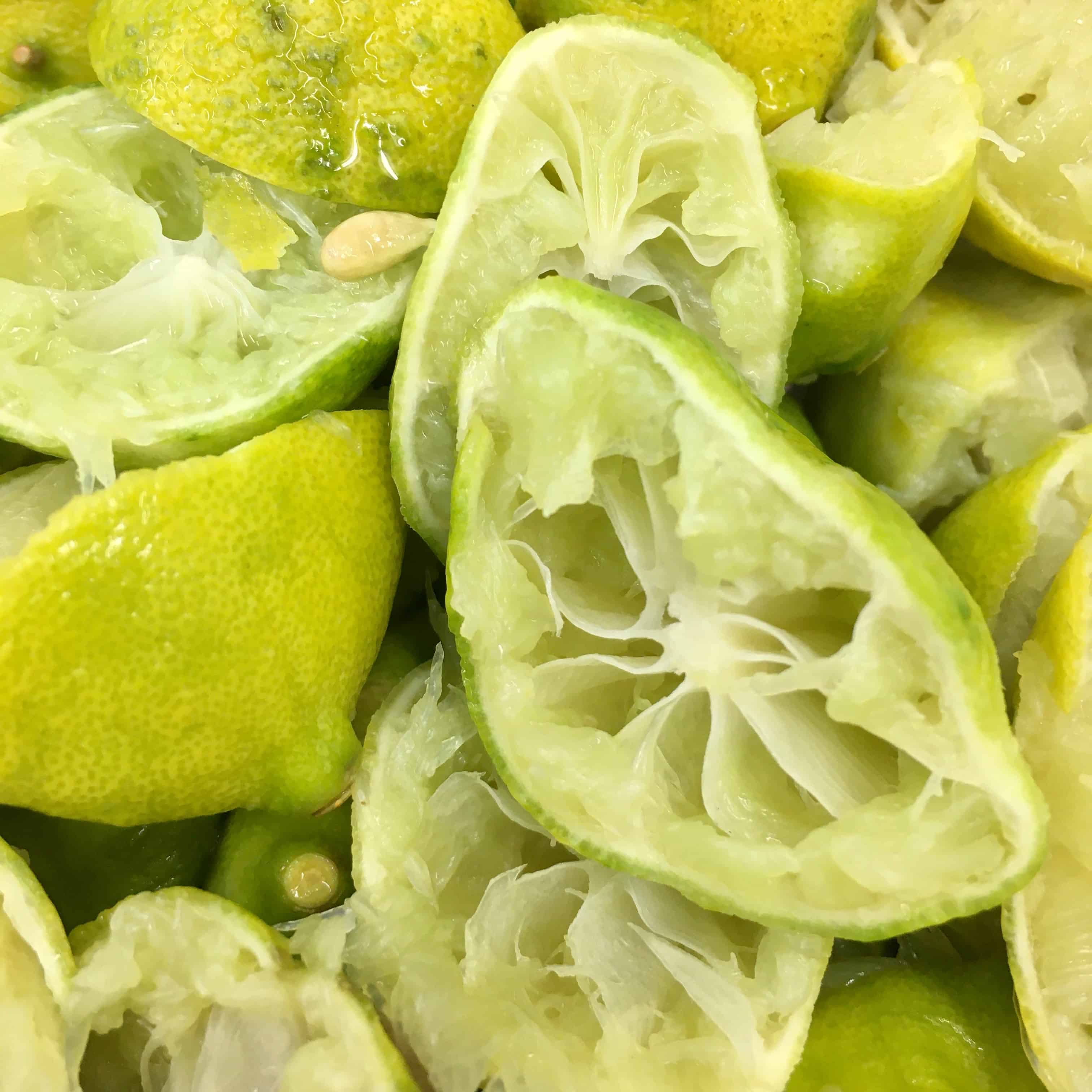 closeup of florida key limes cut in half and all the juice squeezed out of them