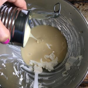 me pouring in the sweetened condensed milk to the cream cheese and lime juice mixture