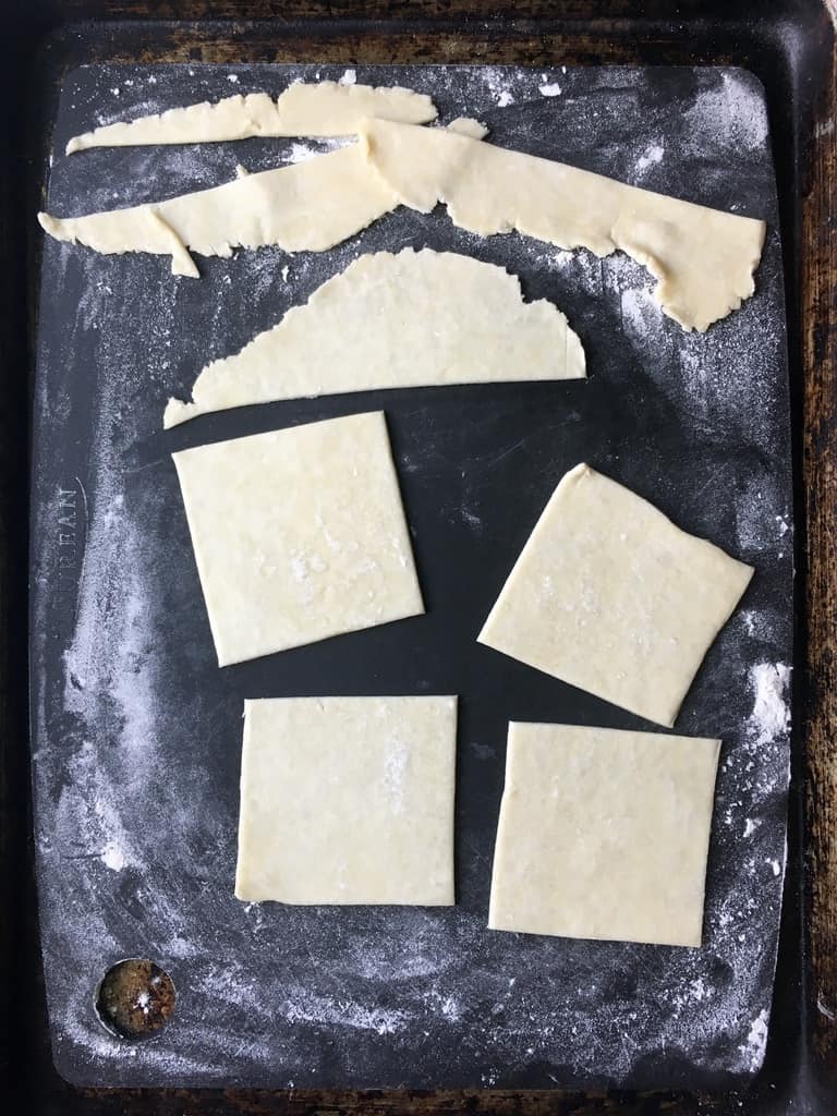 squares of fried pie dough on a black cutting board
