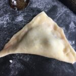 a closed triangle of cherry pie filling in fried pie dough