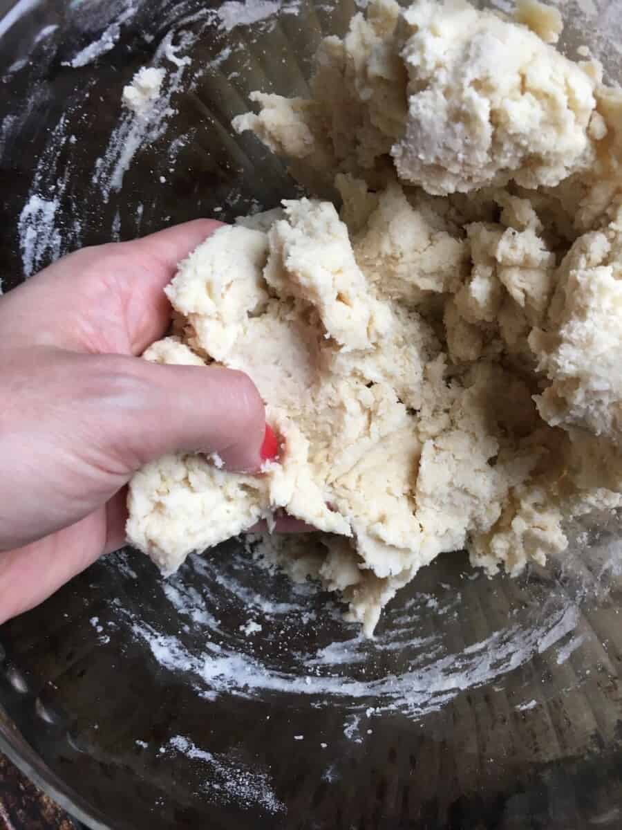 fried pie dough between a hand with red nail polish
