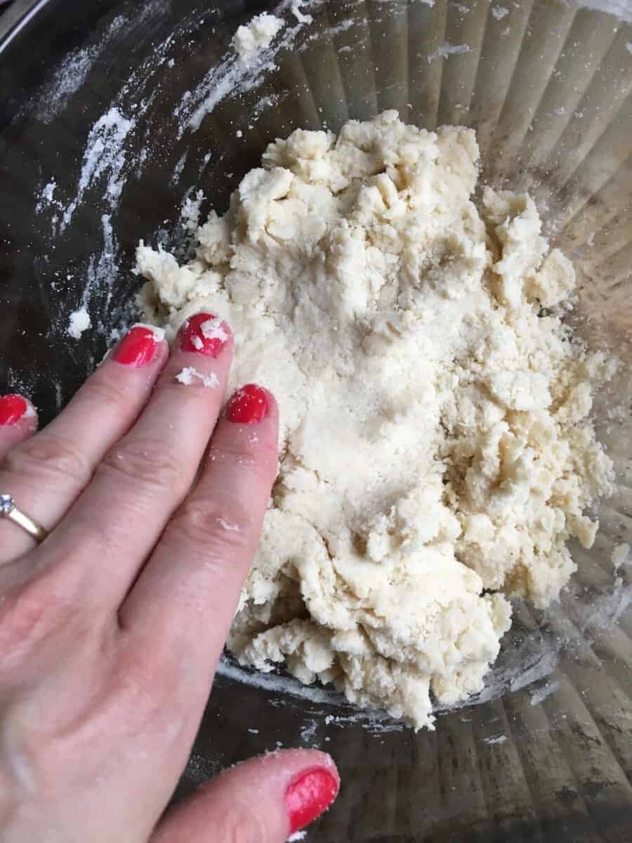 hand patting down the fried pie dough with red nail polish