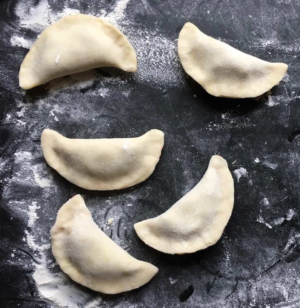 raw cherry fried pies shaped in half-moons without crimped edges