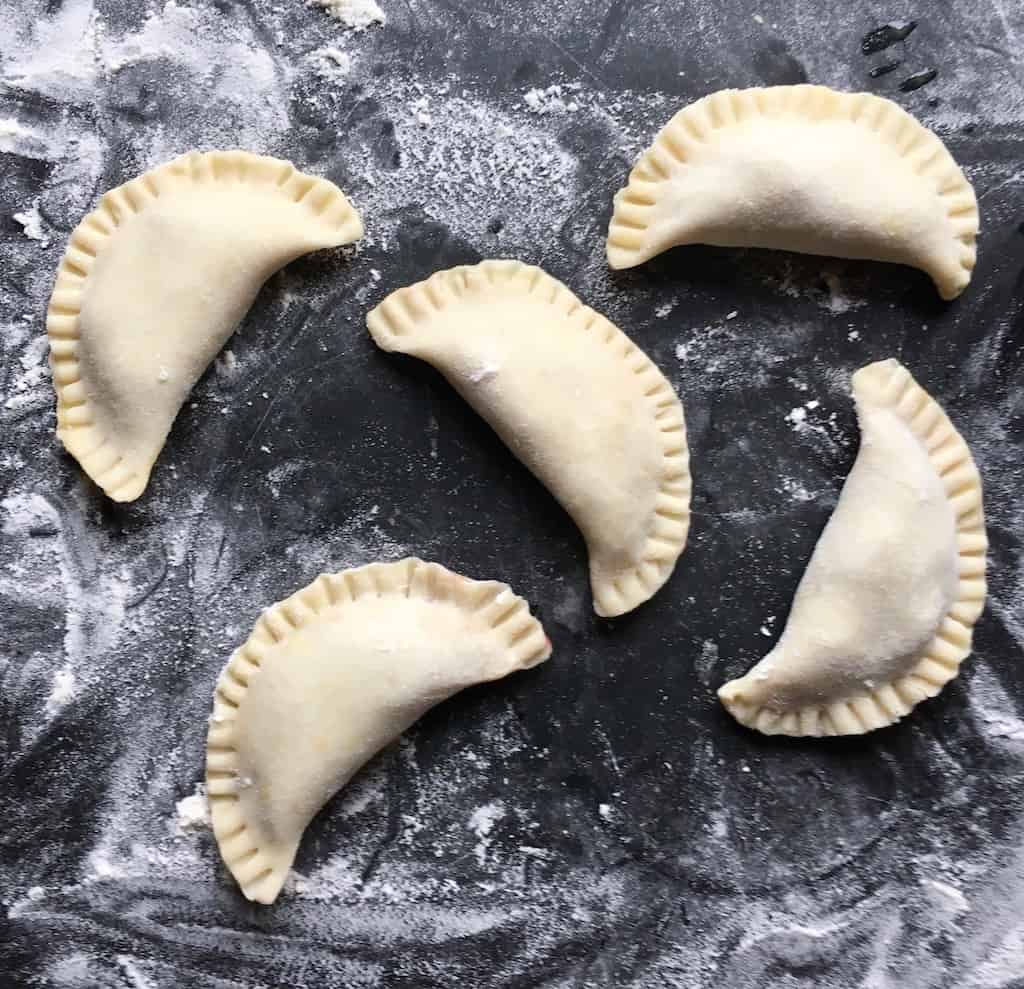 raw cherry fried pies shaped in half-moons with crimped edges