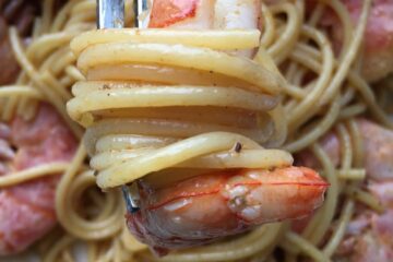 fork holding a mouthful of cajun royal red spaghetti with a shrimp on it