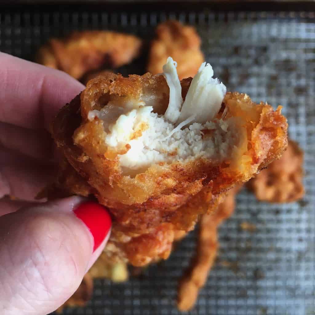 extra crispy fried chicken tender with a bite taken out