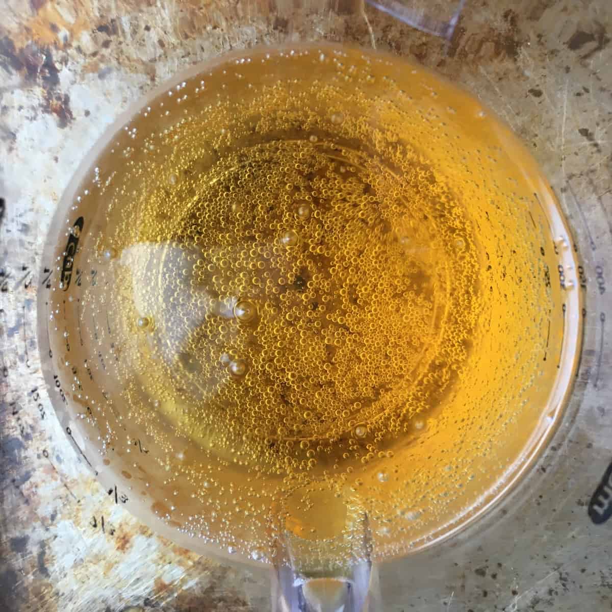 Top down view of crisp light golden beer ready to make beer batter for extra crispy fried chicken tenders recipe.
