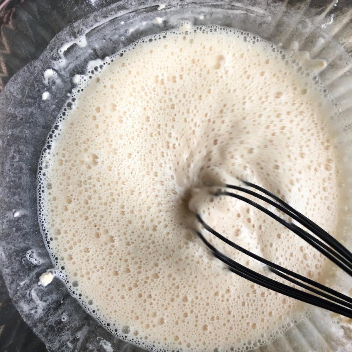 Whisking beer and flour spice mixture together to make beer batter for extra crispy fried chicken tenders showing how to make chicken tenders recipe.
