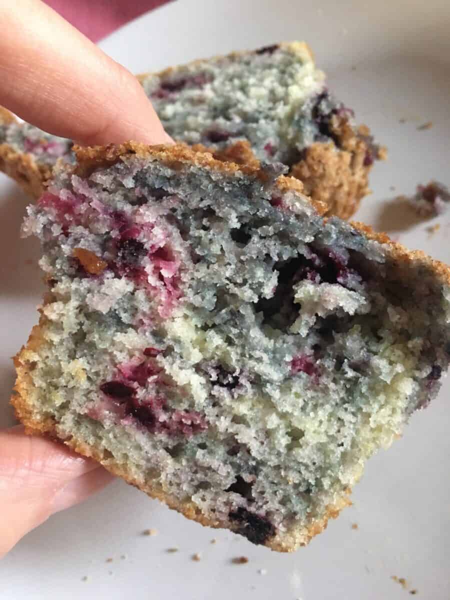 inside of half of muffin held by a finger and thumb to show how moist and colorful they are