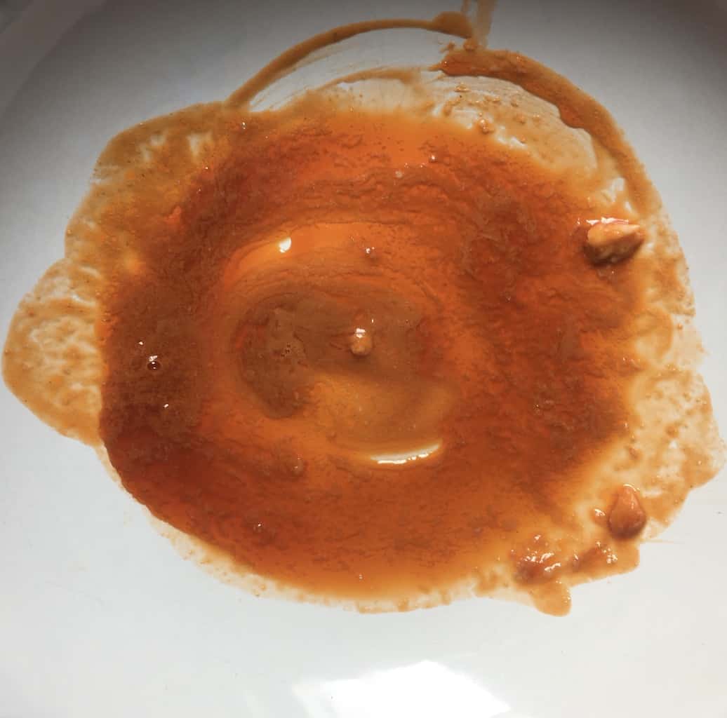 golden orange cooked and strained shrimp heads and shells on a plate