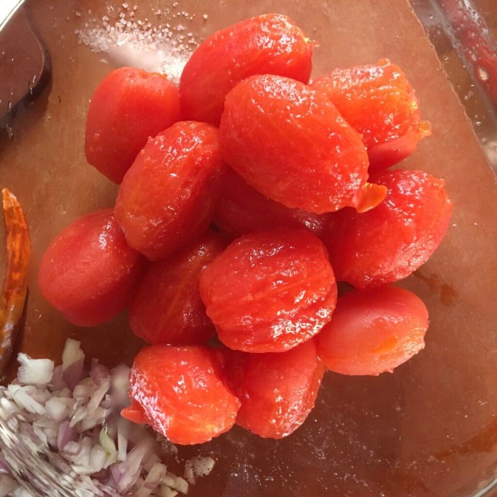 Blanched and peeled grape tomatoes in a bowl for amatriciana sauce.