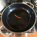 a whole dried red hot chili pepper in the skillet