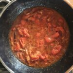 cooking and reducing tomatoes in the Amatriciana sauce
