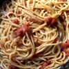 a top down view of delicious spaghetti all amatriciana in a navy blue braising pan