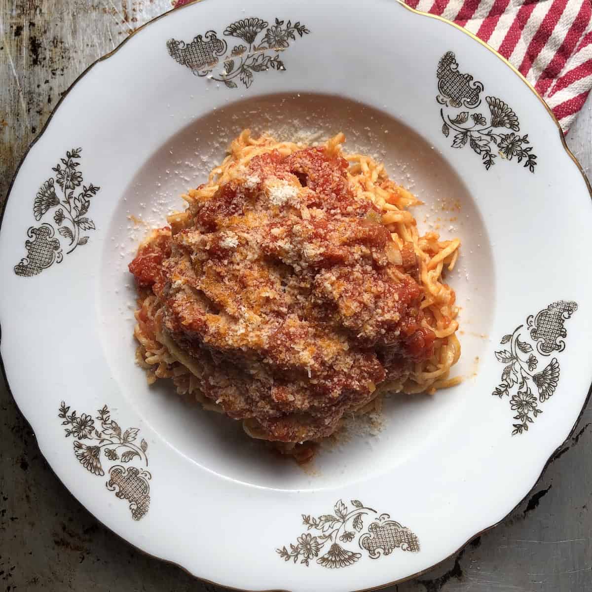 A pasta bowl filled with homemade authentic amatriciana pasta with homemade spaghetti alla chitarra (square spaghetti shape from Abruzzo, Italy) with guanciale and grated pecorino.

