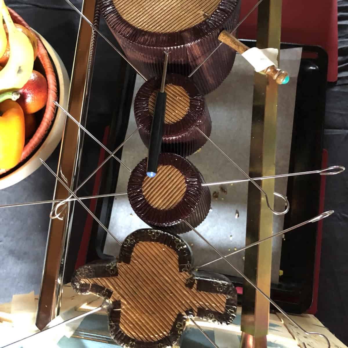 Using metal skewers to hold the homemade Easter dove bread (Italian colomba) so it's secure showing the proper way to cool homemade colomba upside down like they do in Italy, but in a amore secure way to avoid the colomba falling.