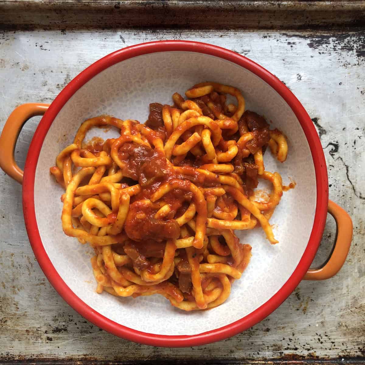 Finished bucatini all'amatriciana made from scratch tossed with amatriciana sauce before adding pecorino cheese.
