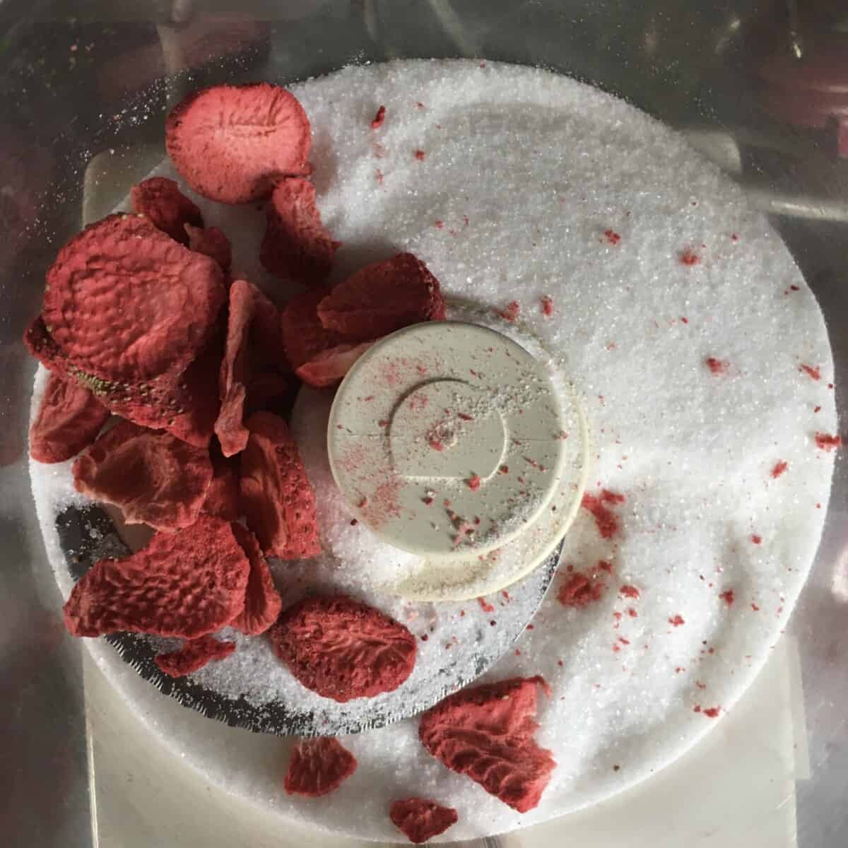 freeze dried strawberry slices and sugar in the bowl of a food processor