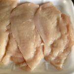 thin chicken breast cutlets raw and ready to be breaded