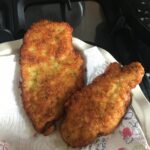 two perfectly fried panko-crusted chicken breast cutlets