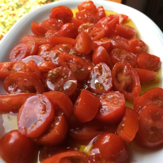 datterino tomatoes with salt and olive oil on a platter in front of a window in the sunlight