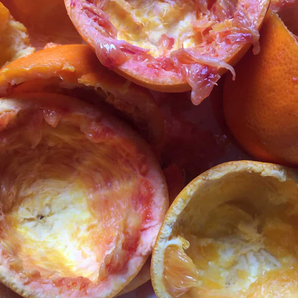 Tarocco blood orange halves juiced and empty with beautiful reds, pinks, oranges and yellows closeup