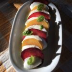 fully dressed and ready to eat Caprese salad with plums and fresh mozzarella