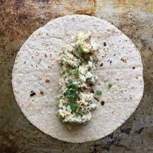 tuna salad just added to the middle of a tortilla wrap