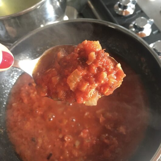pasta sauce on a spoon to show it getting thicker