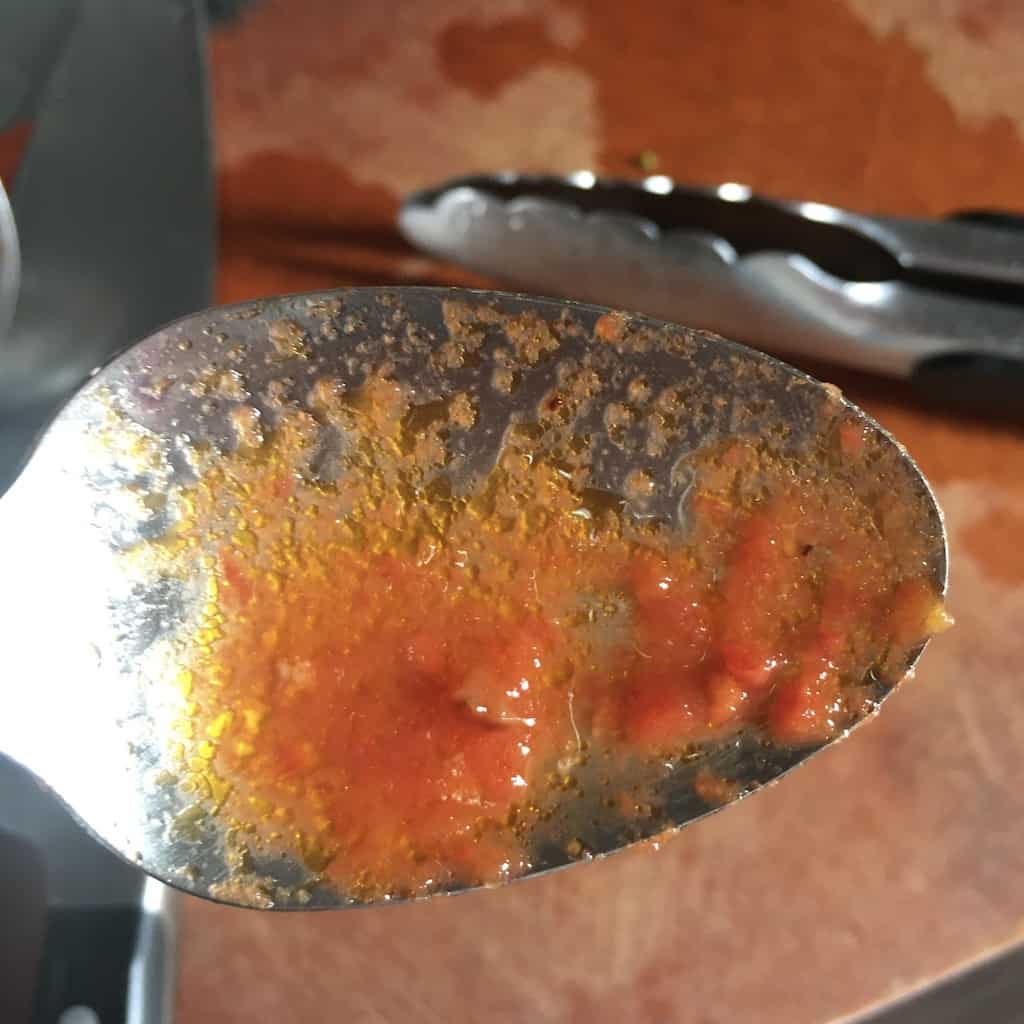 Prosciutto sugo red pasta sauce on a spoon