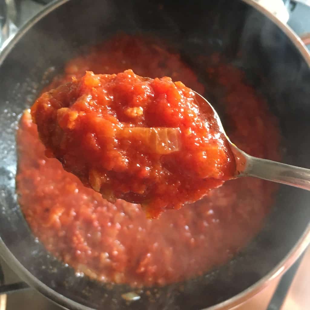 Prosciutto sugo red pasta sauce on a spoon