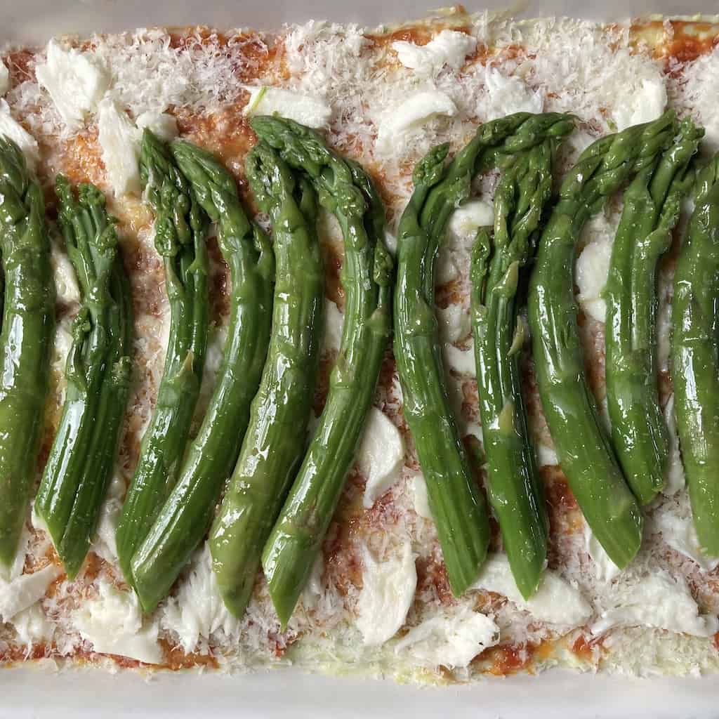pan seared asparagus resting on top of a bed of freshly grated Parm and torn fresh mozzarella as the top layer on this lasagna before being baked