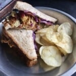 Sesame scallion yellowfin tuna salad on whole wheat bread sliced in half to reveal the best tuna filling and crispy fried onions and shredded purple cabbage for extra texture, served with a side of potato chips. An easy and satisfying lenten lunch idea.