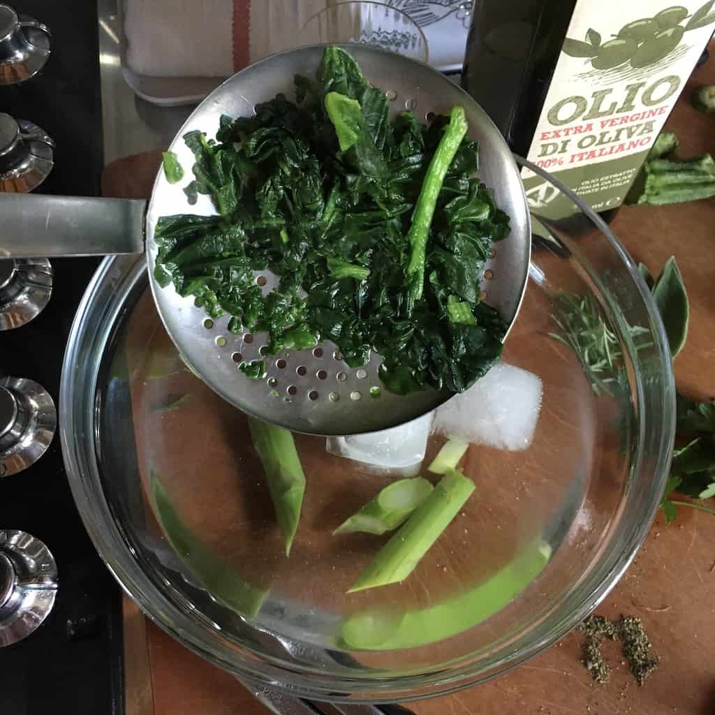 straining the spinach leaves after they've blanched