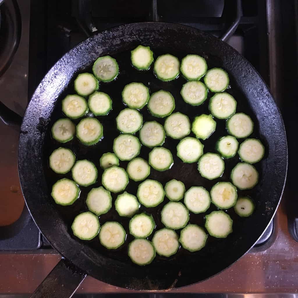 baby zucchini rounds being sautéed in crepe pan