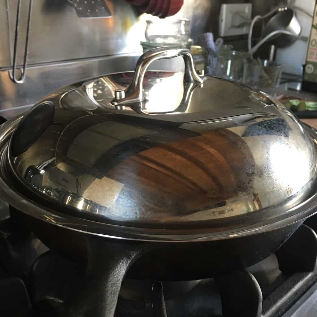 stainless steel lid placed on top of frittata mixture to allow it cook