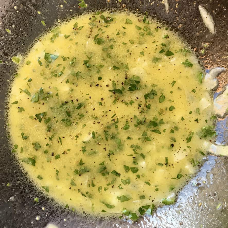 bright yellow vinaigrette speckled with green parsley before adding tomatoes and onion