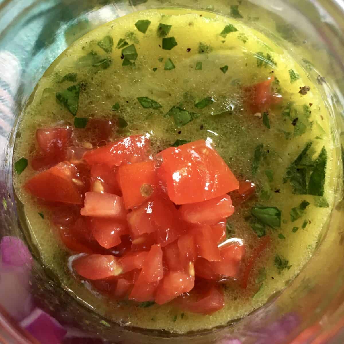 chopped tomatoes on top of lemony-parsley filled olive oil vinaigrette