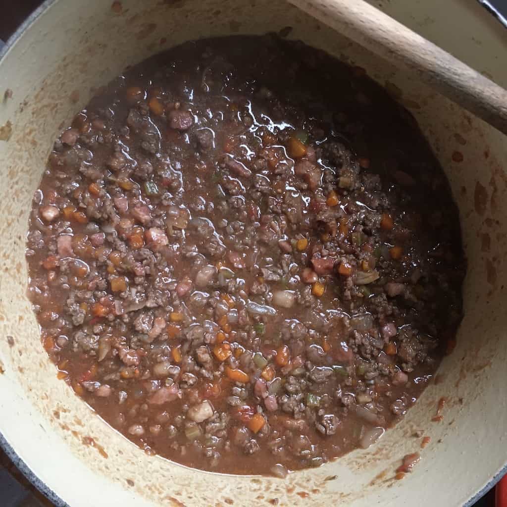 all of the bolognese ingredients added to the sauce and stirred and looking darker in color