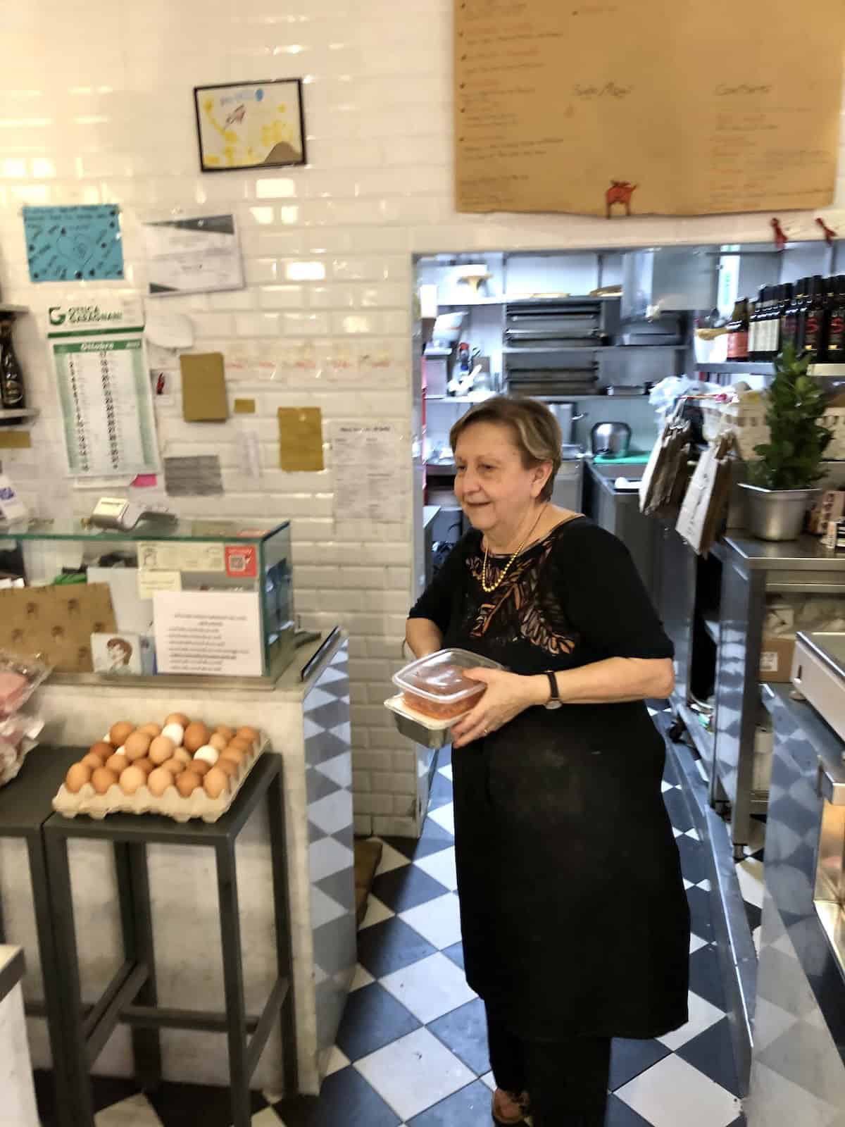 The owner and pastaia at Macelleria Agnoletto and Bagnami in the Quadrilatero area of Bologna Italy where authentic bolognese ragu and lasagna bolognese are made fresh and sold to reheat at home.
