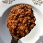 Best bolognese sauce recipe on a wooden spoon showing a rich unctuous texture, authentic bolognese sauce made from scratch with a traditional Italian ragu recipe.