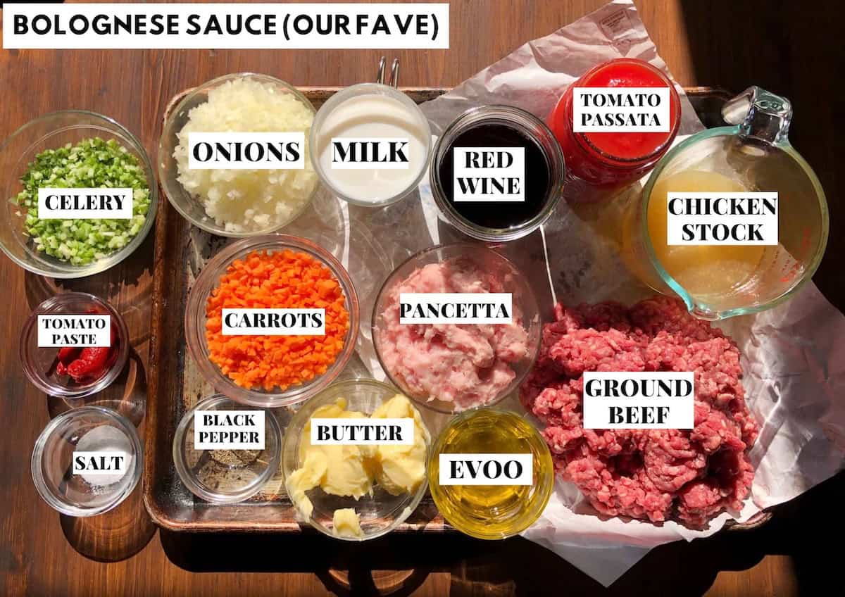 Labeled authentic bolognese sauce ingredients on a sheet pan for a homemade bolognese sauce recipe, how to make bolognese sauce from scratch with traditional Italian ingredients.